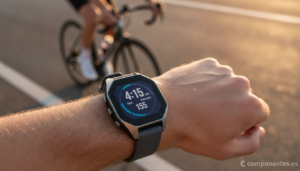 A realistic photo of a modern GPS sports smartwatch on a runner's wrist, close-up shot outdoors on a road at golden hour, ...